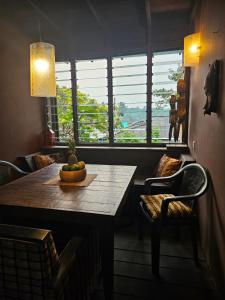 ein Esszimmer mit einem Tisch, Stühlen und einem Fenster in der Unterkunft Busua Beach House in Busua
