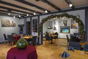 restauracja ze stołami i krzesłami oraz łukiem świątecznym w obiekcie Hotel Restaurant Du Haut Du Roc w mieście Basse-sur-le-Rupt