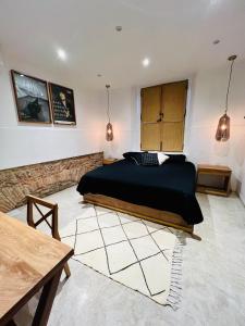 Un dormitorio con una cama y una mesa. en Hotel Atia, en Guadalajara
