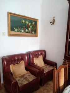 un divano in pelle marrone in una stanza con un dipinto di Piso de 4 habitaciones a O Grove