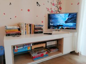 un escritorio blanco con TV y libros en TeglioVacanze, en Teglio