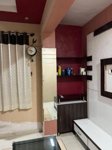 une cuisine avec des murs rouges et une horloge murale dans l'établissement Private room in apartment, à Mire