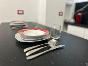 a black table with plates and utensils on it at Maison Valentino in Milan +4 photos