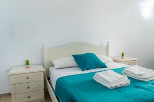 a bedroom with a white bed with blue sheets and pillows at Sea View House 6 in Olbia