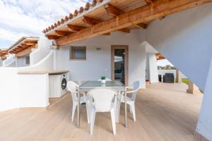 a kitchen and dining room with a table and chairs at Sea View House 6 in Olbia