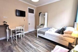 a bedroom with a bed and a table and a desk at Cosy Central Studio off OConnell FAST WIFI in Dublin