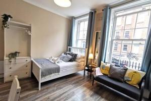 a bedroom with a bed and a large window at Cosy Central Studio off OConnell FAST WIFI in Dublin