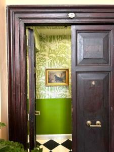 een deur met een groene muur met een schilderij erop bij The Grand Tour Bed & Breakfast in Rome