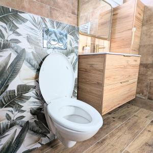 a bathroom with a toilet with a tropical wallpaper at Suite de charme provençale in La Valette-du-Var