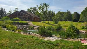 una casa con un estanque frente a un edificio en Grand Chalet, en Bourbon-Lancy