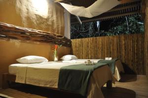 Casa Amazonas في بويرتو مالدونادو: غرفة نوم بسرير مع طاولة ونافذة