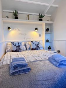 Un dormitorio con una cama con toallas azules. en Capledrae Farmstay Shepherds Huts en Cardenden