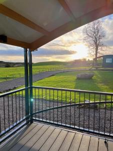 un porche con vistas a un campo en Capledrae Farmstay Shepherds Huts, en Cardenden