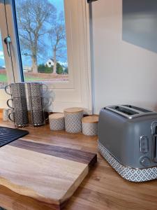 ein Toaster auf dem Boden neben einem Fenster in der Unterkunft Capledrae Farmstay Shepherds Huts in Cardenden