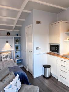 ein Wohnzimmer mit einem Bett und einem Sofa in der Unterkunft Capledrae Farmstay Shepherds Huts in Cardenden