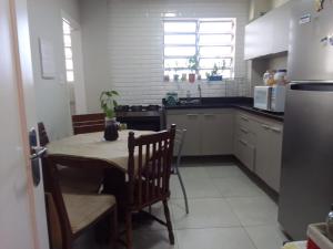 een keuken met een tafel en stoelen en een koelkast bij HOSTEL e POUSADA SALVADOR PRAIA in Salvador