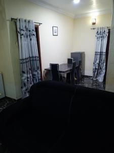 a dining room with a table and chairs and curtains at Treasure Apartment in Lagos