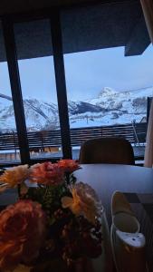 una mesa con flores y vistas a las montañas en Best view Kazbegi en Kazbegi