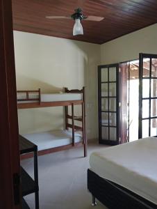 een slaapkamer met 2 stapelbedden en een plafondventilator bij Tropical Paradise in Ubatuba