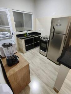a kitchen with a stainless steel refrigerator and a counter at Casa luxuosa em região central (Próximo ao Aeroporto) in Campo Grande