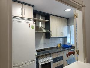 uma cozinha com armários brancos e um frigorífico branco em Apartamento en Motril-costa de Granada em Motril