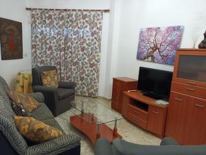 uma sala de estar com um sofá e uma televisão em Apartamento en Motril-costa de Granada em Motril