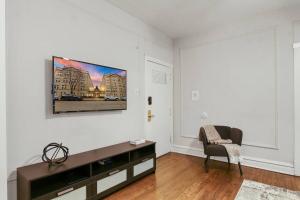 uma sala de estar com televisão numa parede branca em Chic & Contemporary Studio Apartment - Bstone 120 em Chicago