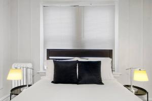 um quarto branco com uma cama com 2 candeeiros em Chic & Contemporary Studio Apartment - Bstone 120 em Chicago