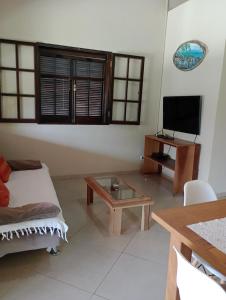 een woonkamer met een bank en een tafel bij Tropical Paradise in Ubatuba