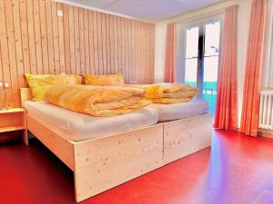 ein Bett mit einem Holzrahmen in einem Schlafzimmer in der Unterkunft Gasthof Ochsen in Nesslau