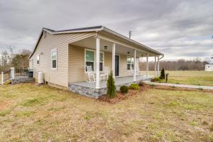 une maison avec une terrasse couverte dotée de 2 chaises blanches dans l'établissement Orange Cottage with Hiking Access 1 Mi to Lake Anna, à Kirk O'Cliff