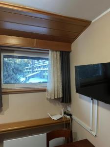 a room with a window and a flat screen television at Apartman 601 i 603 Kopaonik Centar in Kopaonik