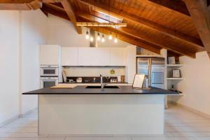 a kitchen with white cabinets and a black counter top at Appartamento open space in Ferno