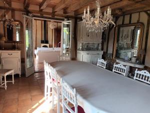 Un comedor con una gran mesa blanca y sillas. en Au bout du monde 2 piscine et spa, en Les Hermites 12 fotos más
