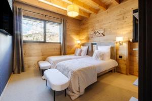 a bedroom with two beds in a log cabin at Chalet Le Bouquetin in Saint-François-Longchamp