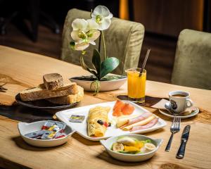 ein Holztisch mit Tellern voller Essen darauf in der Unterkunft Les Fleurs Boutique Hotel in Sofia