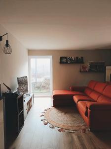 uma sala de estar com um sofá vermelho e uma janela em Bricco Nebbiolo em Neviglie