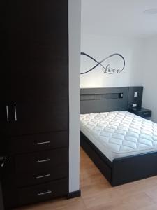 a bedroom with a bed and a black dresser at Departamento completo 2 in Quito