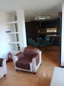 uma sala de estar com duas cadeiras e um sofá em Departamento completo 2 em Quito