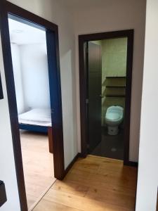 a bathroom with a toilet and a glass door at Departamento completo 2 in Quito