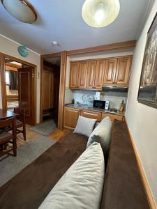 a living room with a couch in front of a kitchen at Apartman 601 i 603 Kopaonik Centar in Kopaonik