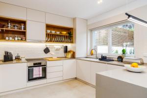 a kitchen with white cabinets and a window at Augusto - your family house in the heart of Lisbon in Lisbon