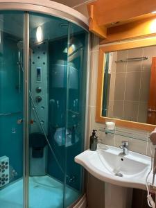 a bathroom with a sink and a glass shower at Apartman 601 i 603 Kopaonik Centar in Kopaonik