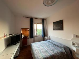 a bedroom with a bed and a flat screen tv at CASABELLA in Monza