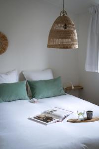 een boek op een wit bed met een lamp bij Buitenlede 7 - Suite M in Dwingeloo