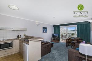 cocina abierta y sala de estar con comedor en Il Centro Apartment Hotel en Cairns