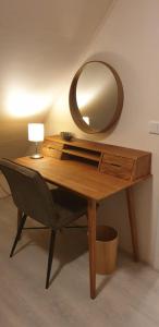 a desk with a mirror and a chair with a lamp at Ermerhoek, in de Hof in Erm