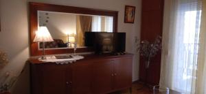 a room with a television on a dresser with a mirror at STEVE'S HOUSE & ELDI in Edessa