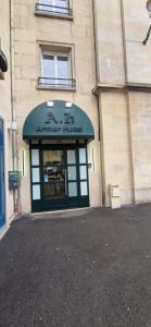 un magasin à l'avant d'un bâtiment muni d'un panneau. dans l'établissement Armor Hotel, à Compiègne