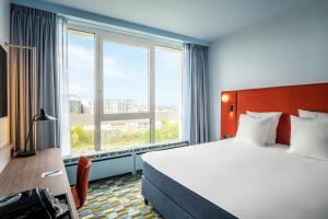 um quarto de hotel com uma cama e uma grande janela em Crowne Plaza Antwerpen, an IHG Hotel em Antuérpia